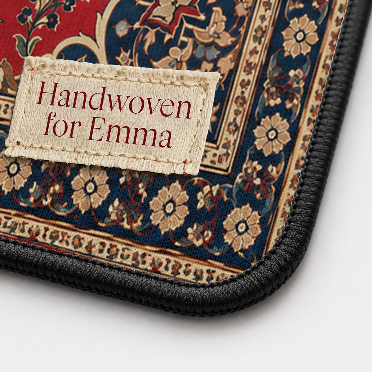 Close-up of the Persian Carpet desk mat corner showing the printed surface and the black stitched edge