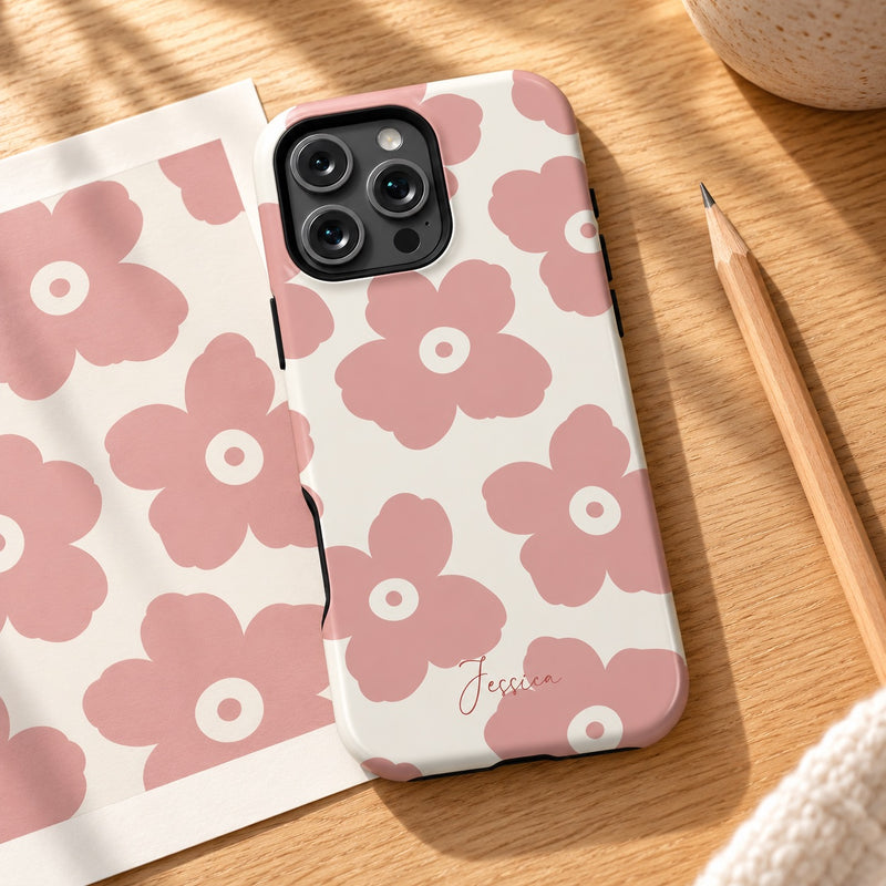 A personalized Soft Bloom phone case on a wooden desk beside its floral artwork print